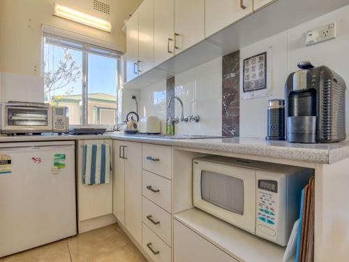 a kitchen with a sink and a microwave at Riverside Studio Minnamurra in Minnamurra