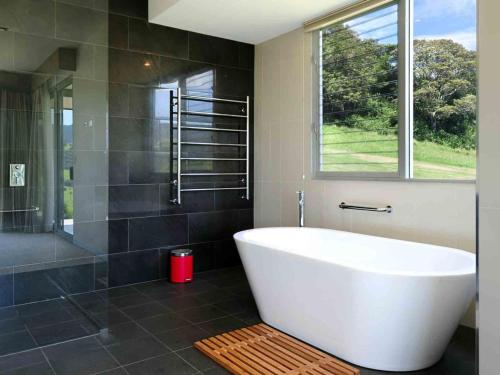ein Badezimmer mit weißer Badewanne und Dusche in der Unterkunft Rose Valley Gerringong in Rose Valley