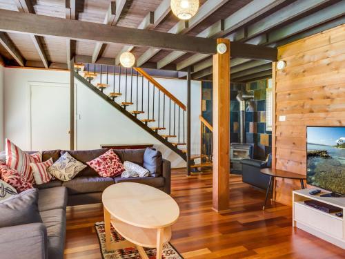 a living room with a couch and a table at Shanti at Hyams Beach in Hyams Beach