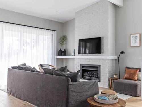 a living room with a couch and a fireplace at The Condo Gerroa in Gerroa