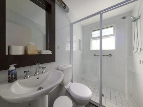 une salle de bain avec un lavabo, des toilettes et une douche dans l'établissement The Beach House Gerroa, à Gerroa