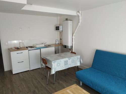 un salon avec un canapé bleu et une table dans l'établissement 3 Sœurs, à Gagny