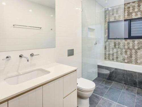 une salle de bain blanche avec toilettes et lavabo dans l'établissement Villa Nova Gerroa, à Gerroa
