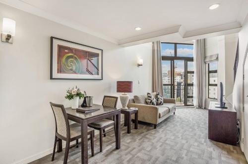 a living room with a table and a couch at Parkside Hotel & Apartments in Auckland