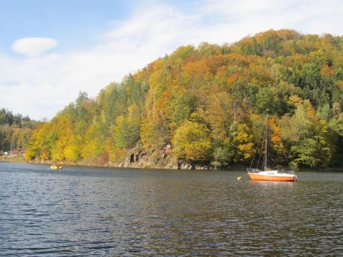 a boat floating on a lake with a mountain at Chata za Górami in Zagórze Śląskie