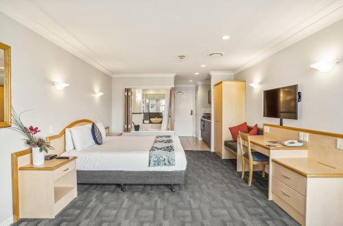 a hotel room with a bed and a desk at Parkside Hotel & Apartments in Auckland
