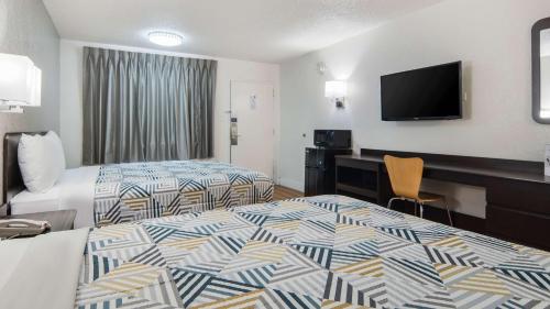 a hotel room with a bed and a television at Motel 6-Addison, TX - Dallas in Addison