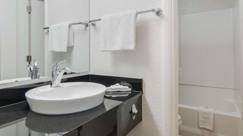 y baño blanco con lavabo y ducha. en Motel 6-Addison, TX - Dallas, en Addison