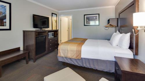 a hotel room with a bed and a flat screen tv at Best Western Clermont in Cincinnati