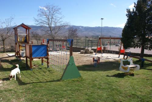 un parque infantil con diferentes tipos de equipos de juego en el césped en Apartamentos Turísticos Reserva de la Biosfera, en Horcajuelo de la Sierra