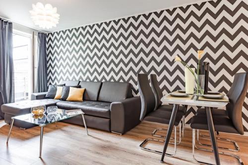 a living room with a couch and a checkered wall at AbsyntApartments Old Town Wroclaw in Wrocław