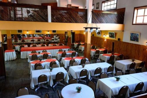 Caparaó Parque Hotel في Caparaó Velho: غرفة طعام مع طاولات وكراسي في مطعم