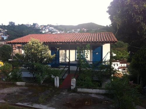 una pequeña casa blanca con techo rojo en Pousada Ciclo do Ouro, en Ouro Preto