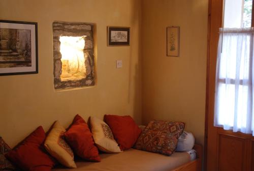 a living room with a couch with many pillows at Kamene Priče rooms, music and food in Bale