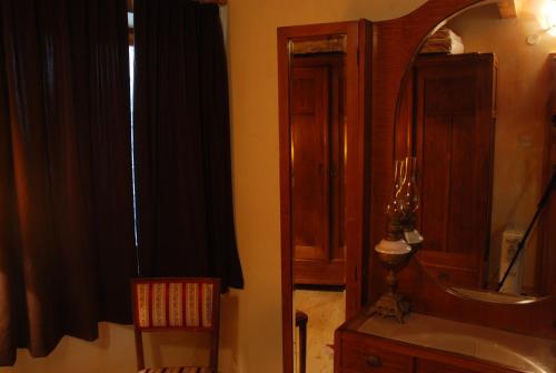 a bathroom with a mirror and a sink and a chair at Kamene Priče rooms, music and food in Bale