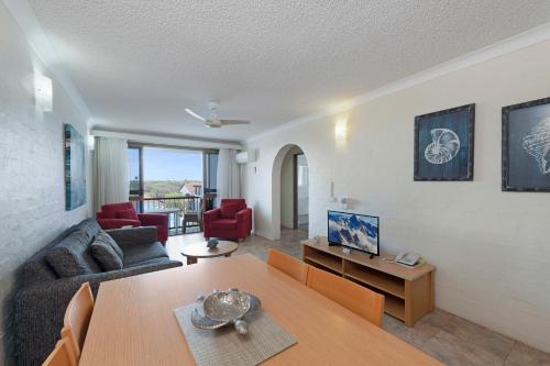 a living room with a couch and a table at Don Pancho Beach Resort in Bargara