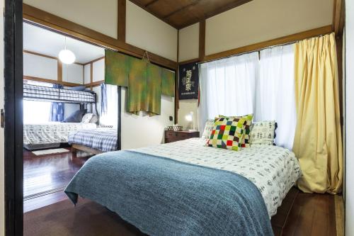 ein Schlafzimmer mit einem Bett mit einer blauen Decke in der Unterkunft Samurai House - Large Family House, West Shinjuku in Tokio