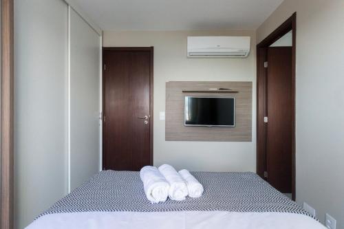 a hotel room with a bed with towels on it at Luxuoso Flat de 2 qts ao lado do CASV e do Riomar in Recife