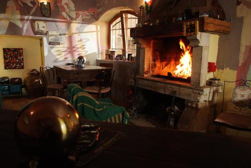 a fire in a fireplace in a room with a table at Kamene Priče rooms, music and food in Bale