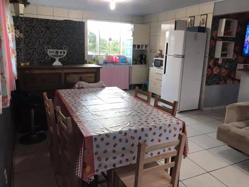 a kitchen with a table and a kitchen with a refrigerator at Residencial Segundo Piso in Garopaba