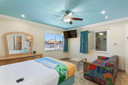 una camera con letto e ventilatore a soffitto di Bay Palms Waterfront Resort - Hotel and Marina a St Pete Beach