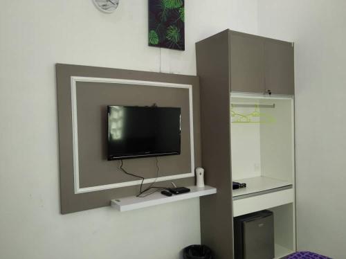 a flat screen tv on a wall with a mirror at Captain's Cabin Resort - Naval Heritage (Swimming Pool) in Kota Bharu
