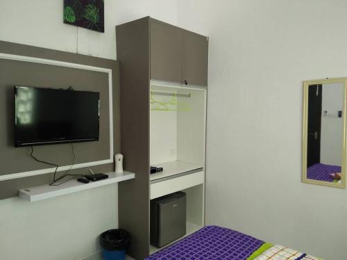 a bedroom with a tv and a bed and a mirror at Captain's Cabin Resort - Naval Heritage (Swimming Pool) in Kota Bharu