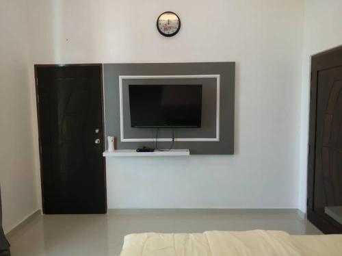 a living room with a tv on a wall at Captain's Cabin Resort - Naval Heritage (Swimming Pool) in Kota Bharu