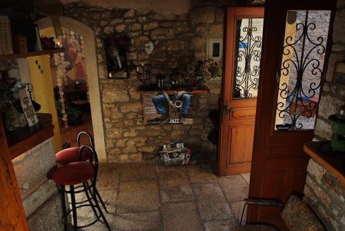 a room with a door and a table and a chair at Kamene Priče rooms, music and food in Bale