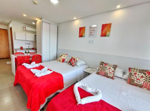 a bedroom with two beds with red and white sheets at Manawa Beach Flats Prime in Porto De Galinhas