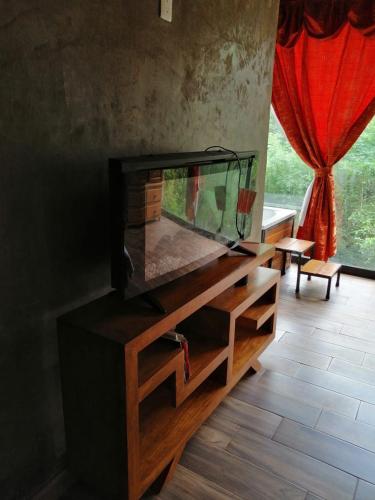 a fishtank on a wooden cabinet in a room with a window at Mazamitla Pinos del Rio in Mazamitla