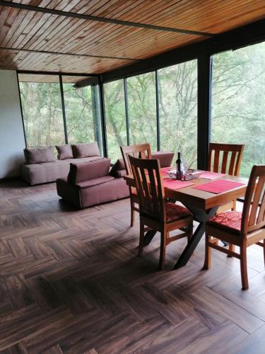 a dining room with a table and chairs and a couch at Mazamitla Pinos del Rio in Mazamitla