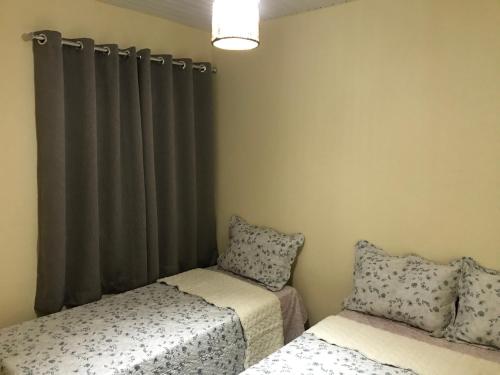 - une chambre avec 2 lits et une fenêtre avec des rideaux dans l'établissement GA3-Hospedagem Próximo ao Aeroporto de Guarulhos, à Guarulhos
