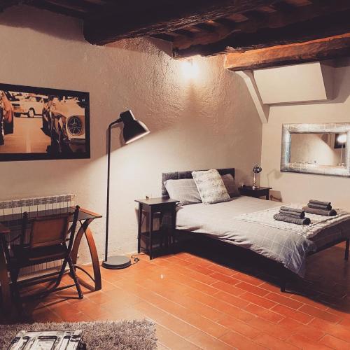 1 dormitorio con cama, escritorio y lámpara en Mirabella - Monte Petriolo, en Monte Petriolo