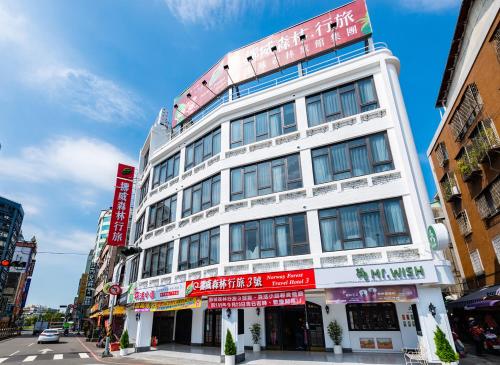 a tall white building with red signs on it at Norway Forest Travel hotel 3 Taichung in Taichung