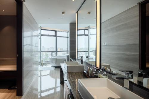 een badkamer met 2 wastafels en een grote spiegel bij Hotel Nikko Suzhou in Suzhou