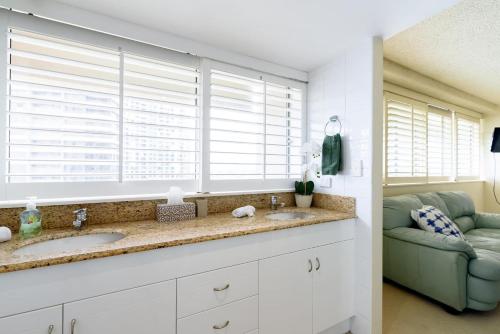 La salle de bains est pourvue d'un lavabo et d'une fenêtre. dans l'établissement Main Beach Waterfront Apartment, à Gold Coast
