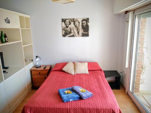 a bedroom with a red bed with two pillows on it at Luminoso monoambiente en Recoleta in Buenos Aires