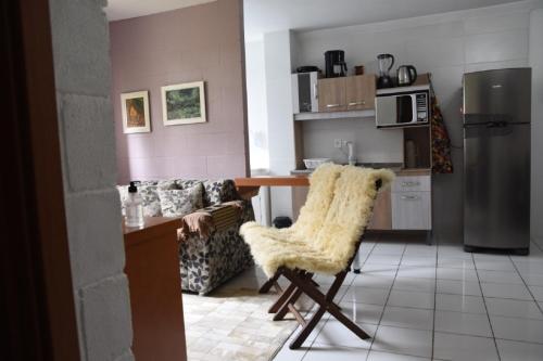 cocina con sofá, mesa y silla en Apartamento Canela Bela en Canela