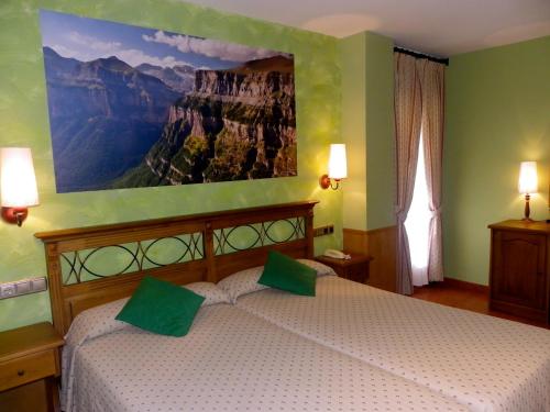 1 dormitorio con 1 cama con una pintura en la pared en Hotel Arnal, en Escalona