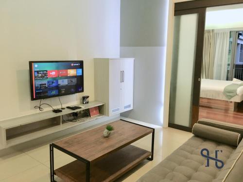 a living room with a tv and a coffee table at Homesuite' Home at The Loft in Kota Kinabalu