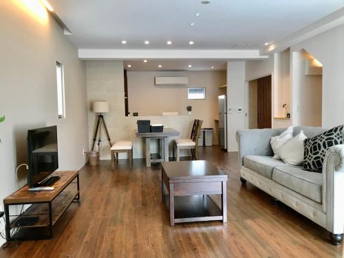 a living room with a couch and a table at D-and Stay HH.Y Resort Okinawa in Teruya