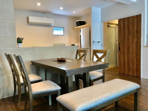 eine Küche und ein Esszimmer mit einem Holztisch und Stühlen in der Unterkunft D-and Stay HH.Y Resort Okinawa in Teruya