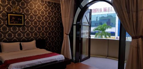 a bedroom with a bed and a large window at Linh Phương 1 Hotel in Can Tho