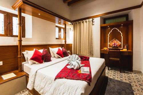 a bedroom with a bed with a stuffed animal on it at KSTDC Hotel Mayura Hoysala, Mysore in Mysore