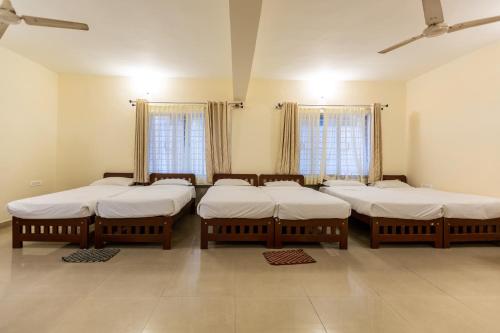 a group of mattresses in a room with windows at KSTDC Hotel Mayura Hoysala, Mysore in Mysore