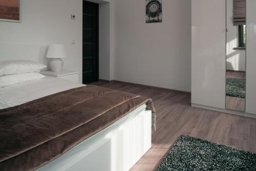 a bedroom with a bed with white walls and wooden floors at Laurentroom Center in Ukmergė