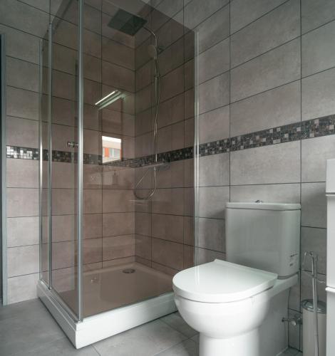 a bathroom with a toilet and a shower and a tub at Laurentroom Center in Ukmergė