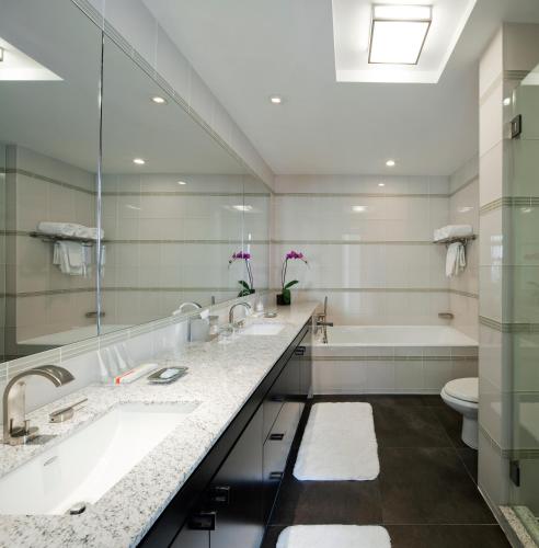 a bathroom with two sinks and a tub and a toilet at Royalton Park Avenue in New York