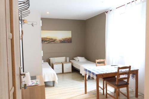 mały pokój z 2 łóżkami i stołem w obiekcie City Apartments & Gym we Wrocławiu